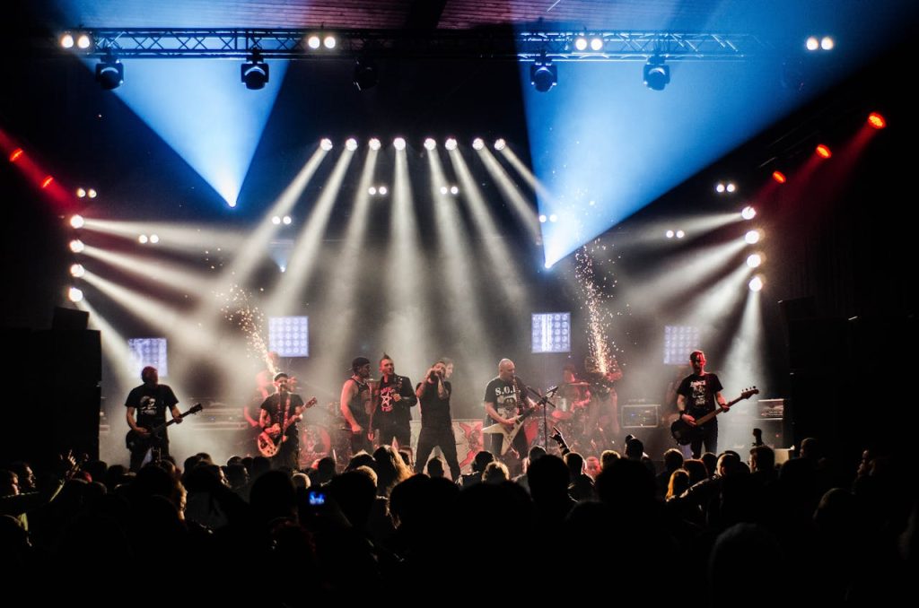 Energetic live band performance under vibrant stage lights captivating a large audience.